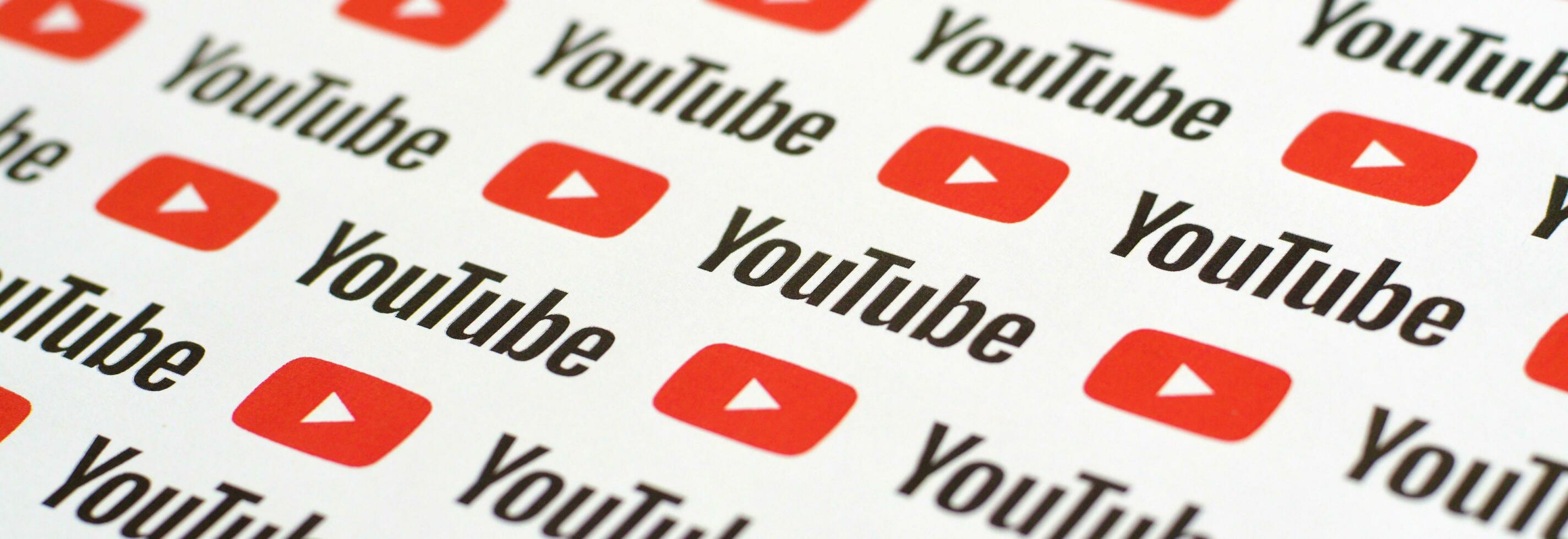 Youtube pattern printed on paper with small youtube logos and inscriptions. YouTube is Google subsidiary and American most popular video-sharing platform photo