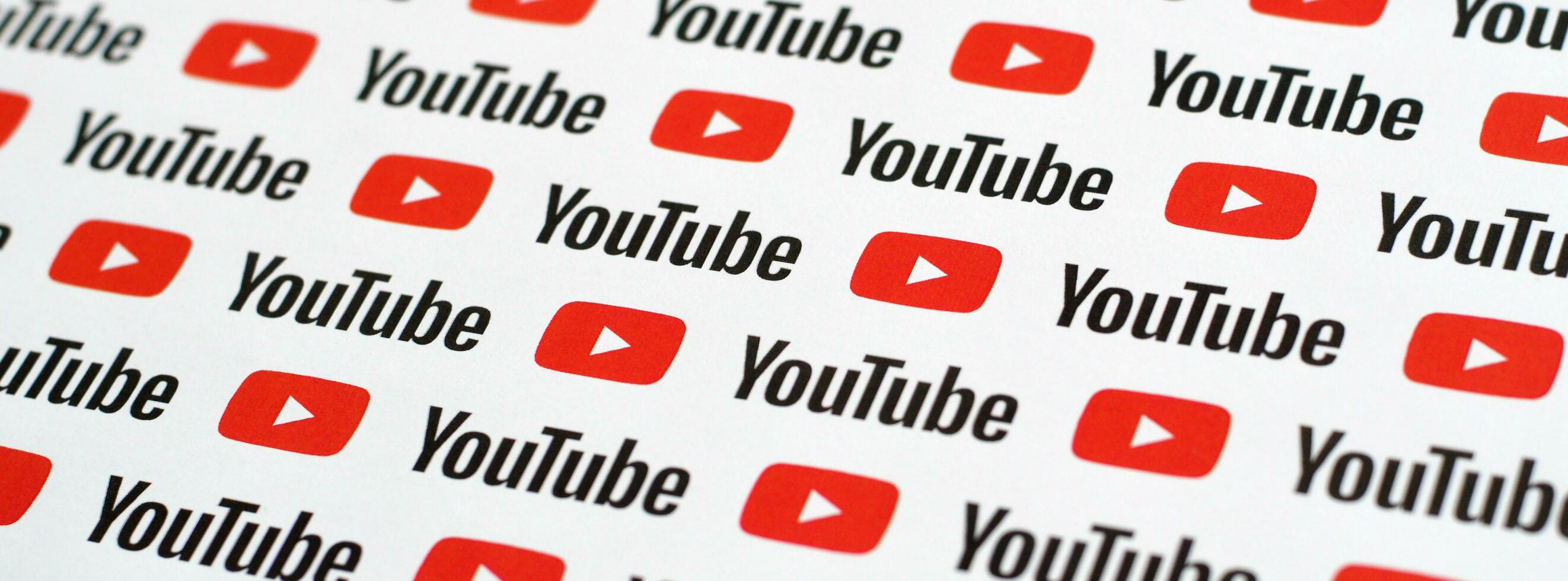 Youtube pattern printed on paper with small youtube logos and inscriptions. YouTube is Google subsidiary and American most popular video-sharing platform photo