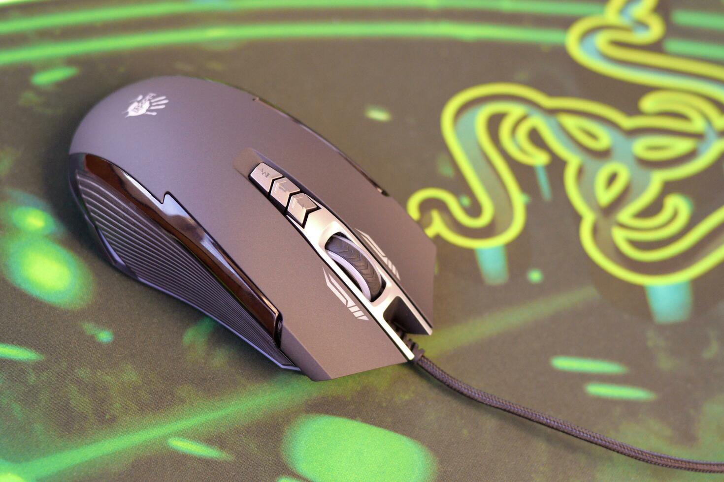 P93 Bloody cybersport gaming mouse by A4Tech lies on Razer Goliathus mouse pad. Professional cybersport supply photo