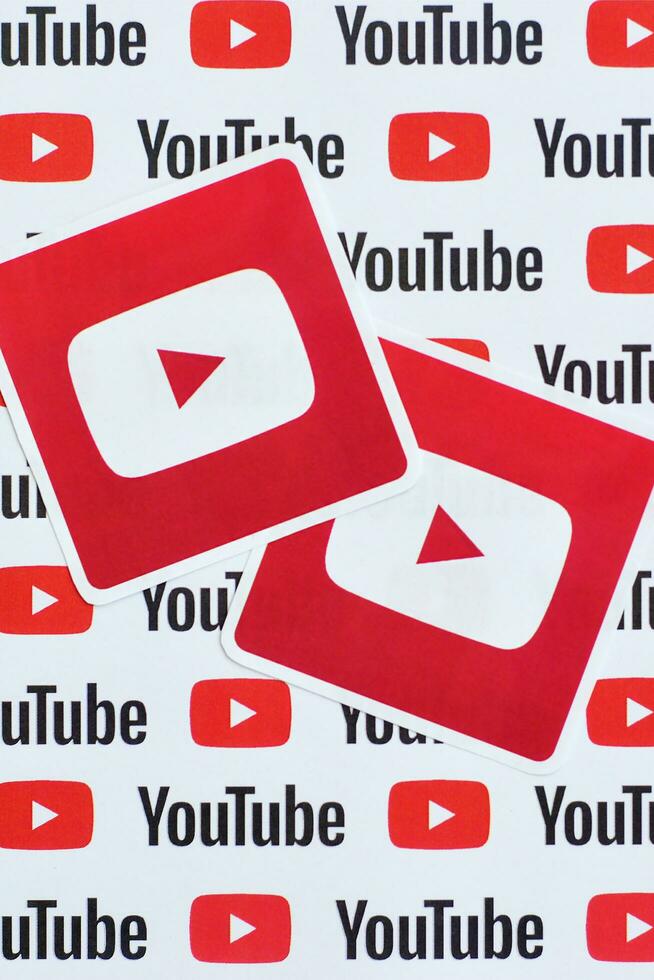 Youtube logo sticker on pattern printed on paper with small youtube logos and inscriptions. YouTube is Google subsidiary and American most popular video-sharing platform photo