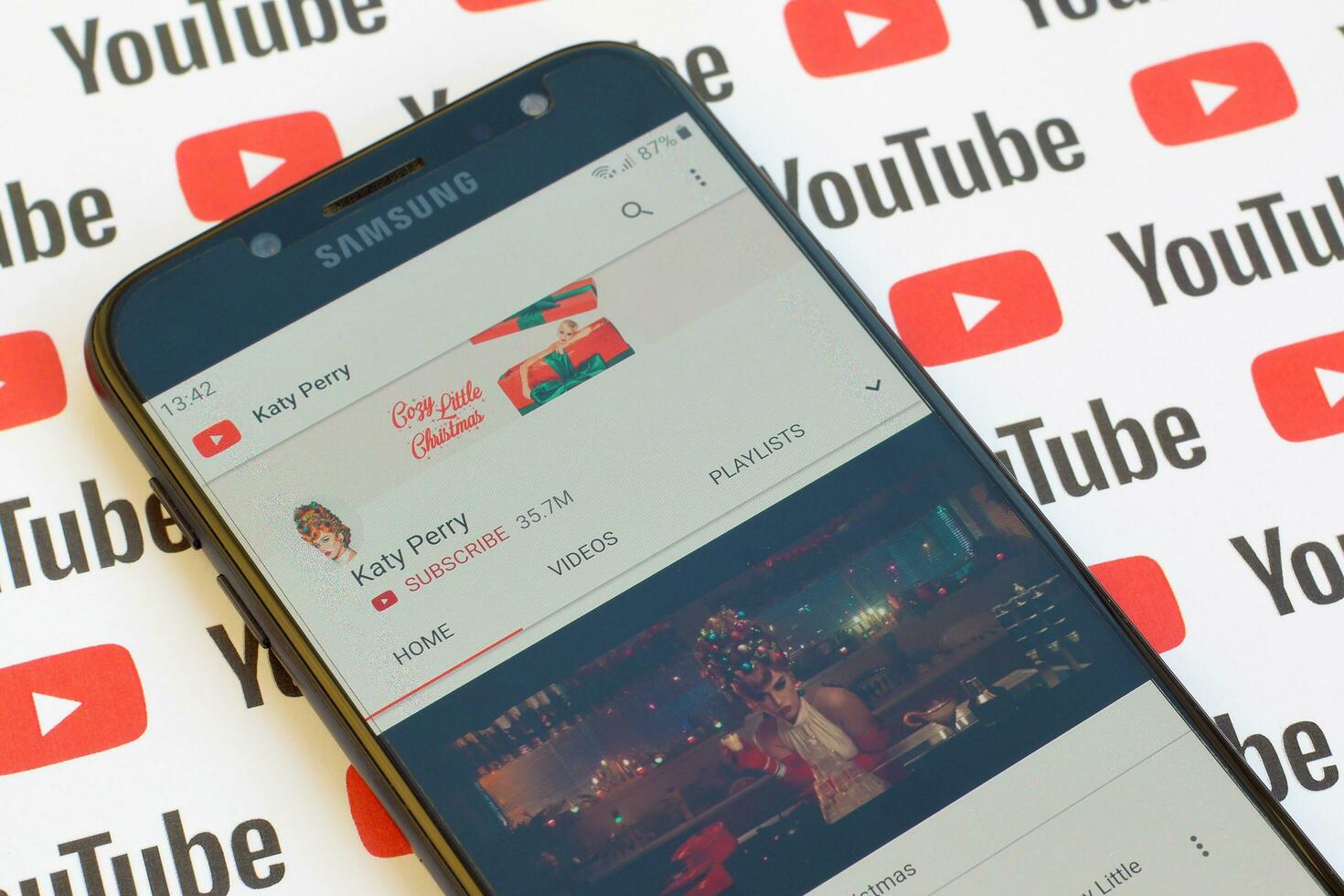 Katy Perry official youtube channel on smartphone screen on paper youtube background. photo