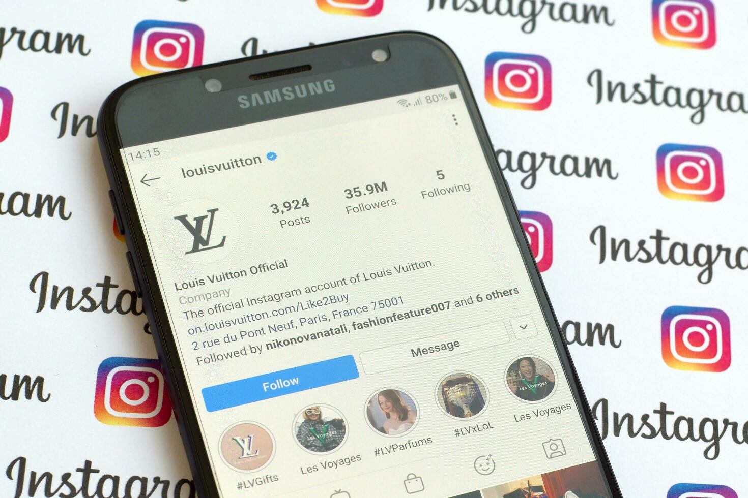Louis Vuitton official instagram account on smartphone screen on paper instagram banner. photo