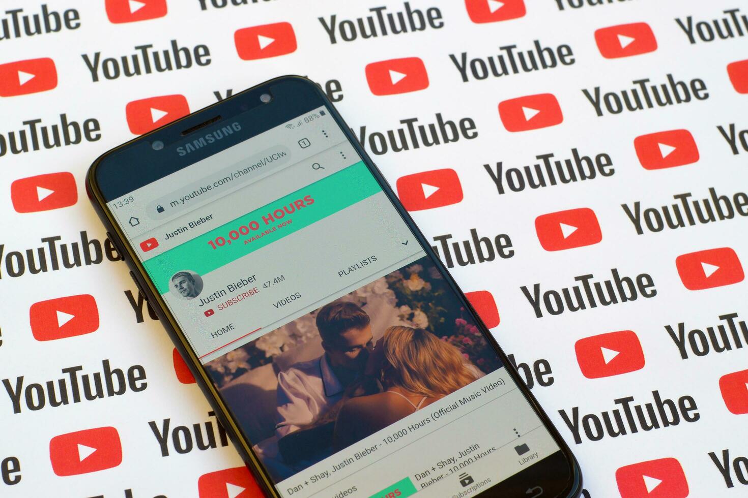 Justin Bieber official youtube channel on smartphone screen on paper youtube background. photo