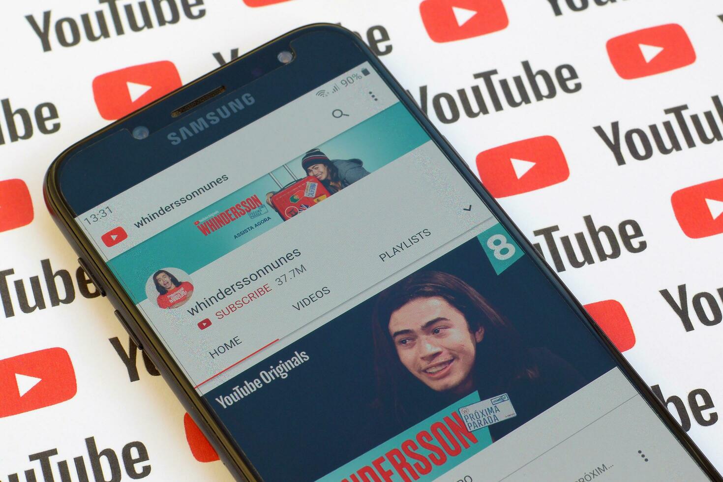 Whinderssonnunes official youtube channel on smartphone screen on paper youtube background. photo