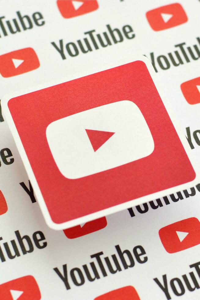 Youtube logo sticker on pattern printed on paper with small youtube logos and inscriptions. YouTube is Google subsidiary and American most popular video-sharing platform photo