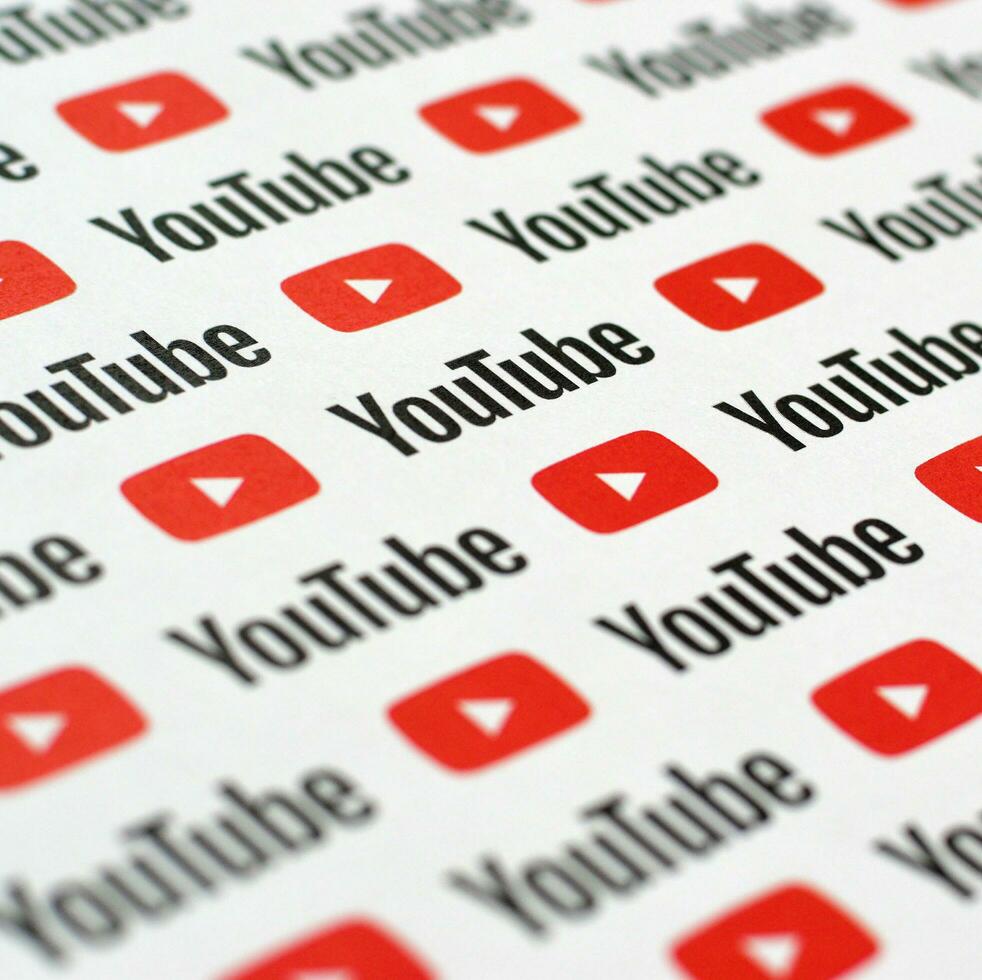 Youtube pattern printed on paper with small youtube logos and inscriptions. YouTube is Google subsidiary and American most popular video-sharing platform photo