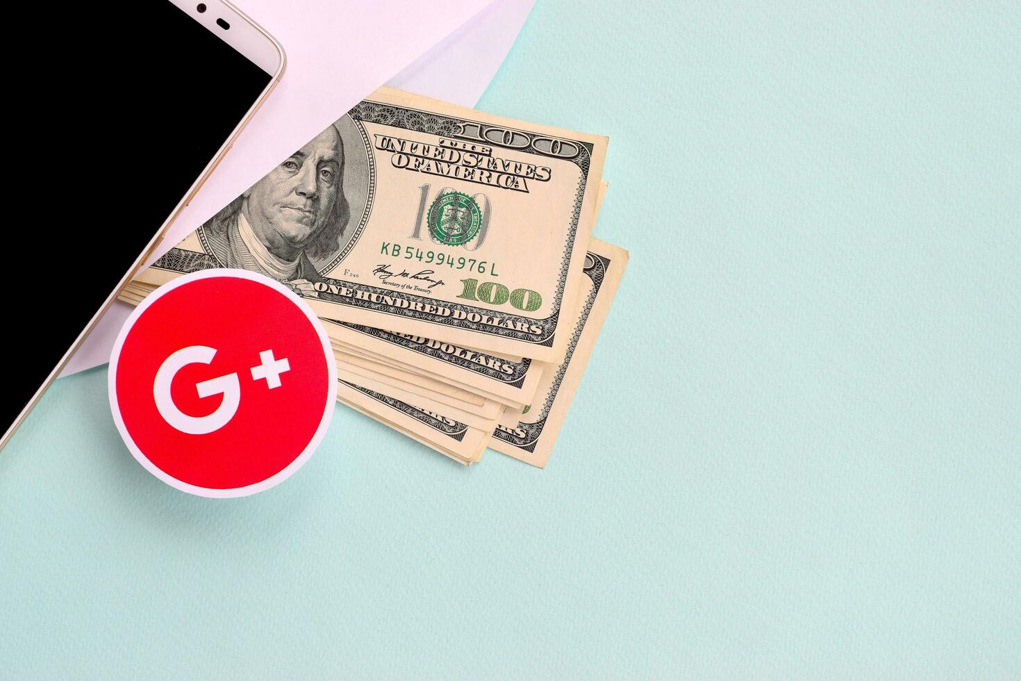 Google plus paper logo lies with envelope full of dollar bills and smartphone photo
