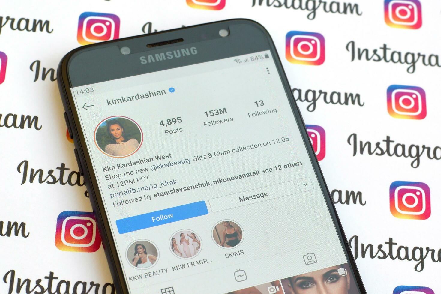 Kim Kardashian West official instagram account on smartphone screen on paper instagram banner. photo
