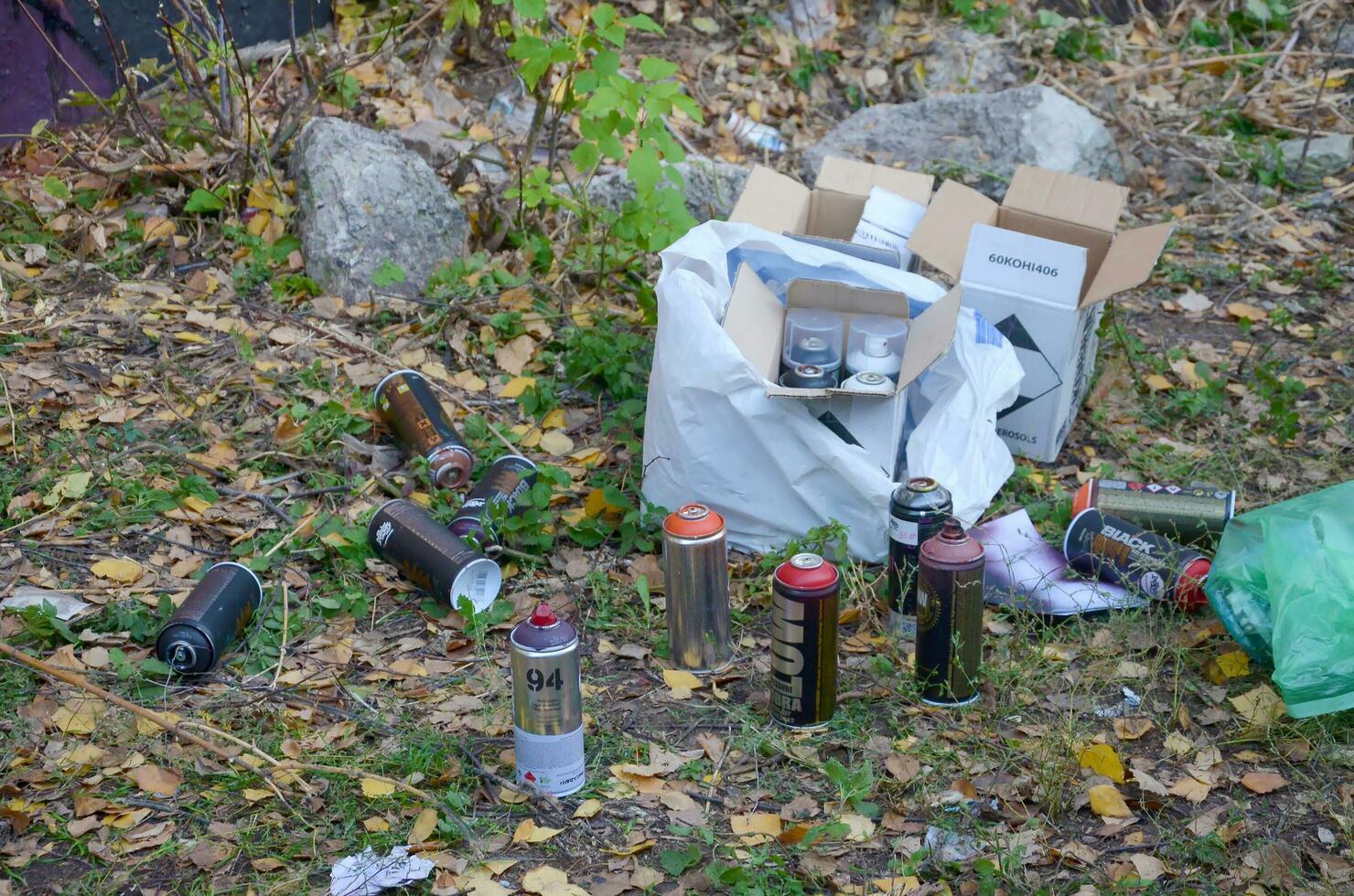KHARKOV, UKRAINE - OCTOBER 19, 2019 Montana mtn 94 black hardcore dope and kobra used spray cans for graffiti painting outdoors in autumn leafs photo