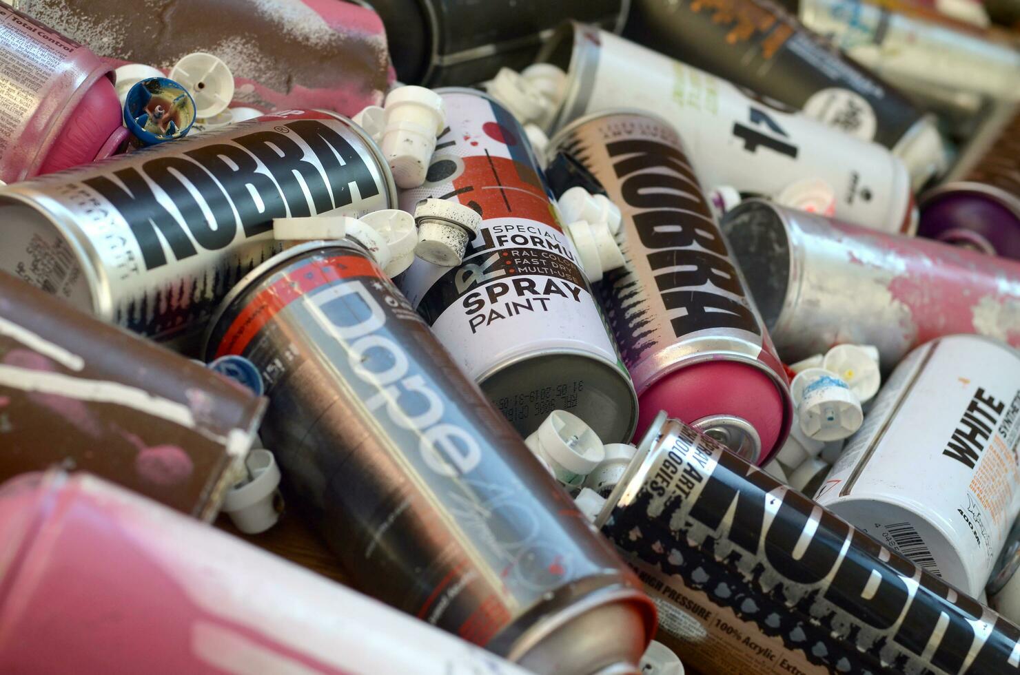 Montana mtn 94 black hardcore dope and kobra used spray cans for graffiti painting lies on wooden background photo