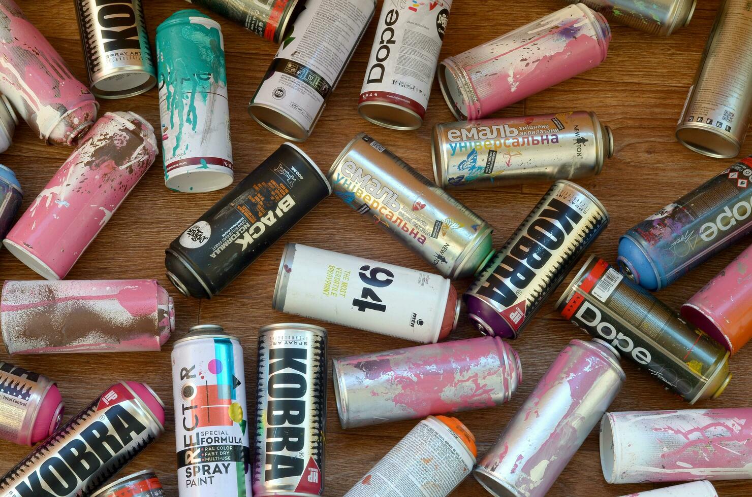 Montana mtn 94 black hardcore dope and kobra used spray cans for graffiti painting lies on wooden background photo
