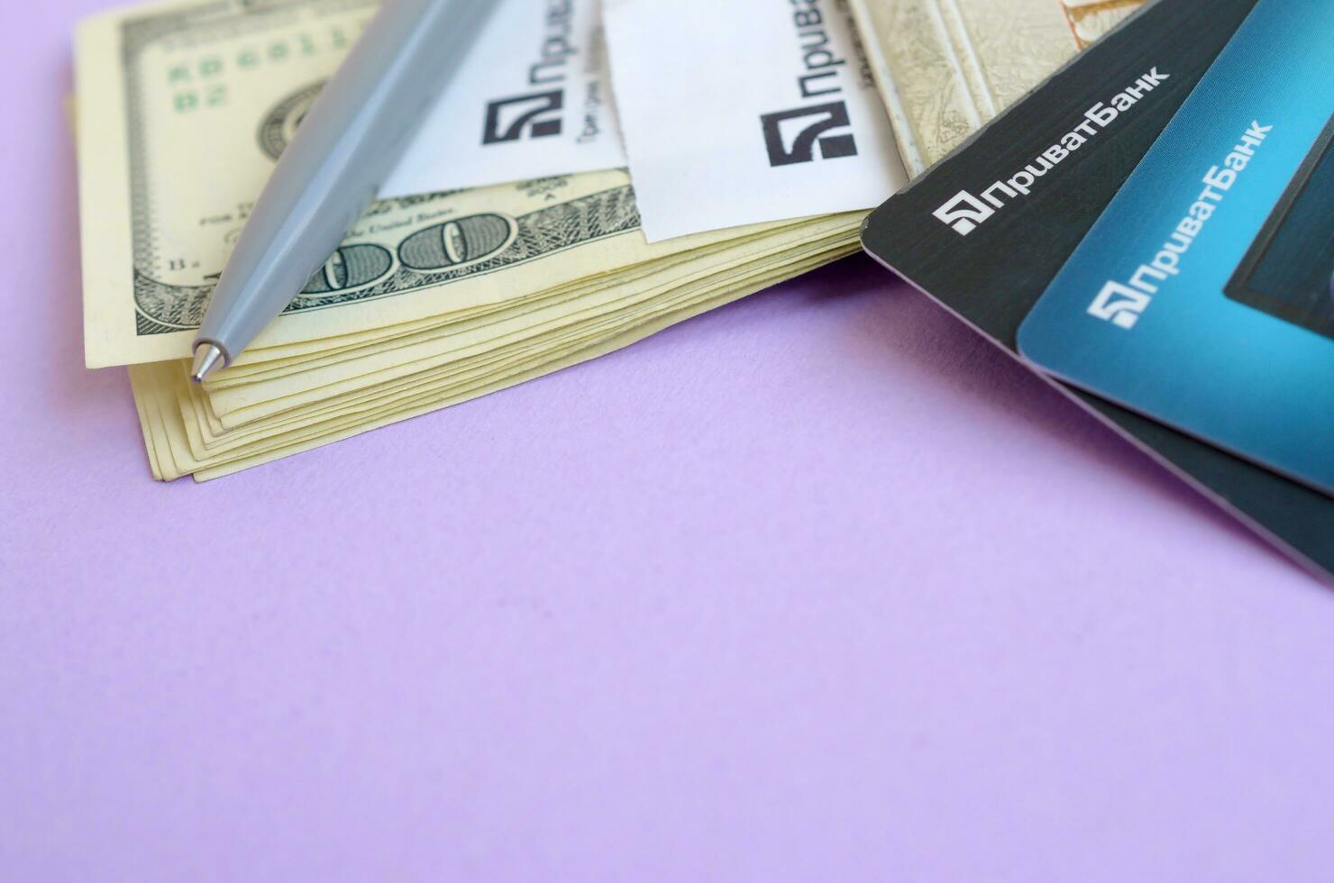 Privatbank check lies with credit cards and pen on dollar bills with passport. Privatbank is a main financial department in Ukraine, depository of money in hryvnia photo