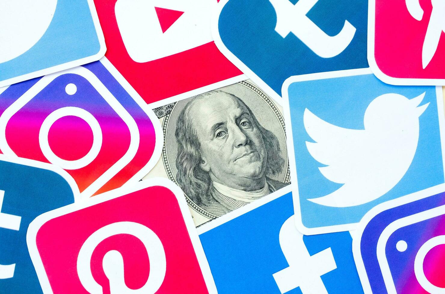 Benjamin Franklin hundred dollars bill portrait with printed logo of many social networks. Facebook Instagram Youtube Tumblr Twitter Pinterest photo
