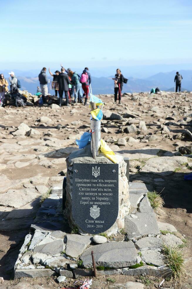 CARPATHIAN MOUNTAINS, UKRAINE - OCTOBER 8, 2022 Ukrainian monument at peak of Hoverla mountain in Carpathians photo