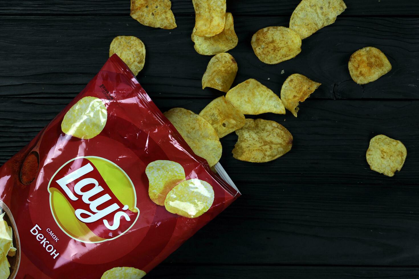 KHARKOV, UKRAINE - JANUARY 3, 2021 Lays potato chips with bacon flavour and original lays logo in middle of package. Worldwide famous brand of potato chips photo