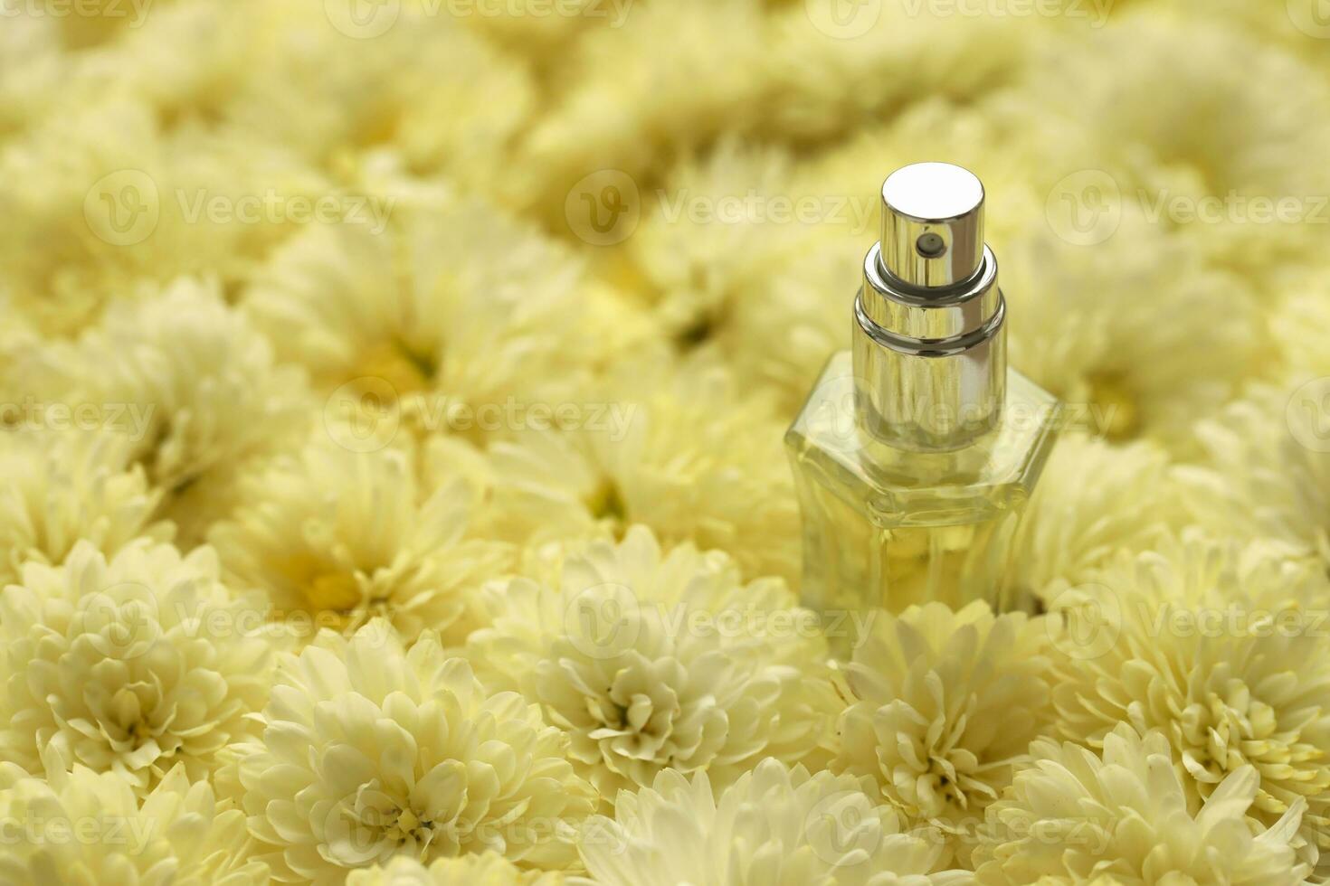 Women fragrance perfume bottle with flowers background close up. Unnamed blank sprayer bottle of perfume photo