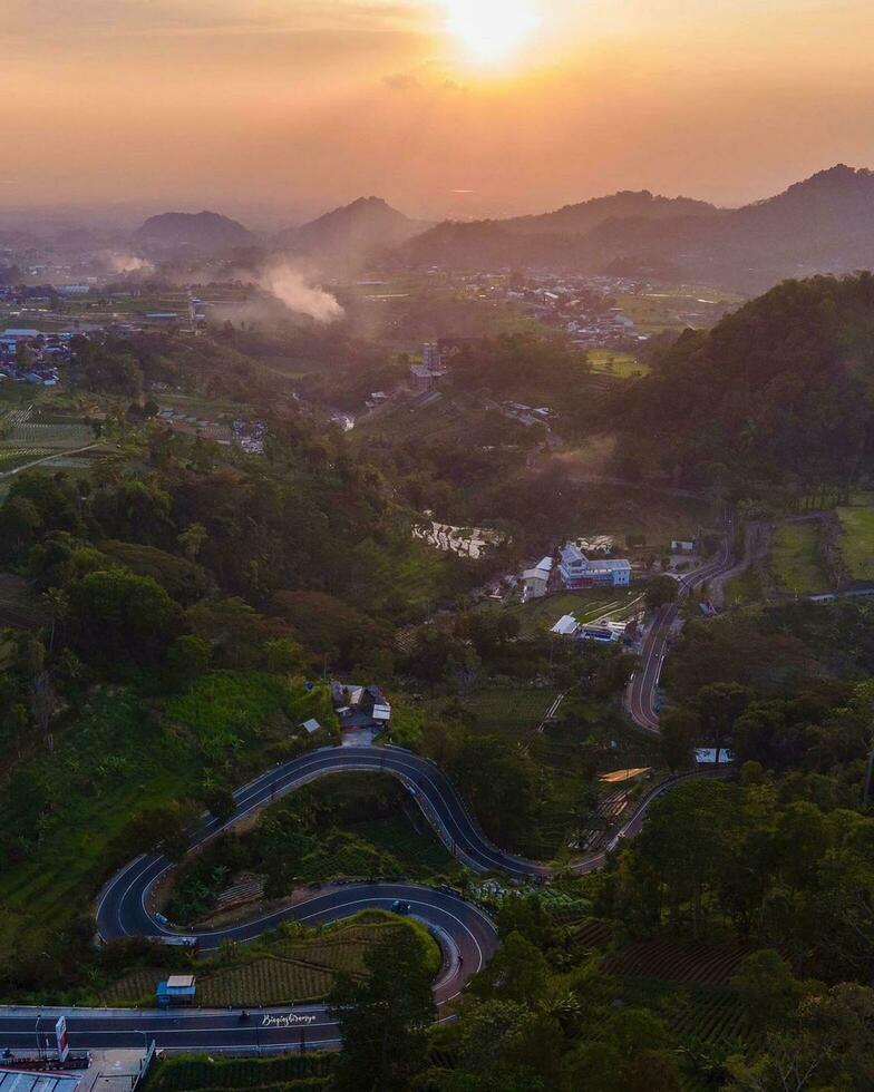 Bird's Eye View of a Breathtaking Cityscape at Sunset,Bird's eye view of a city nestled in nature, with sunset hues. photo