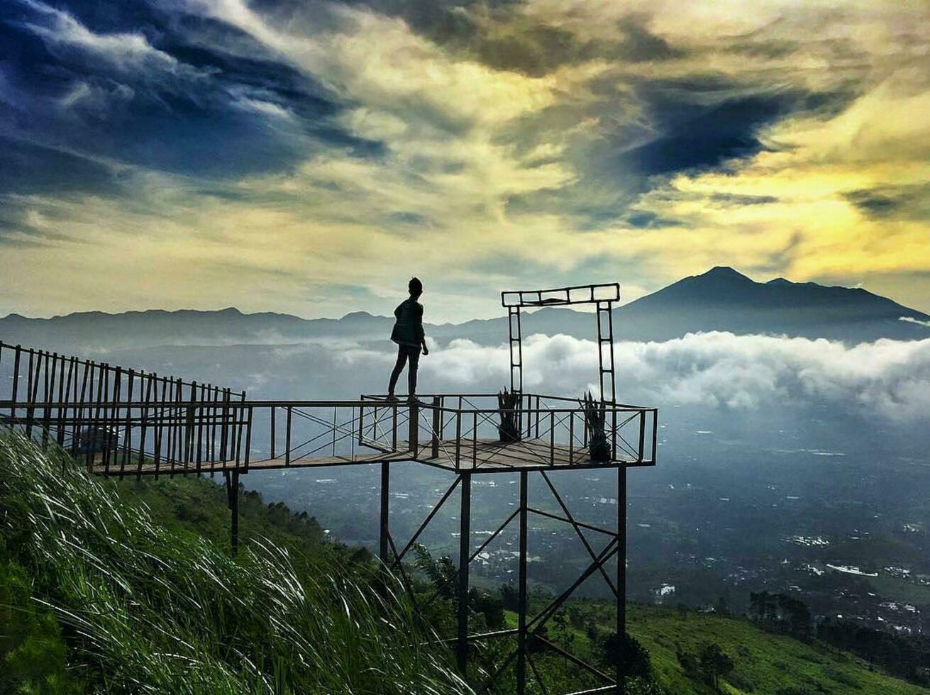 Morning's Beauty in Nature Person Enjoying Coastal Landscape with Ocean and Mountain Views Breathtaking coastal architecture harmonizes with serene nature and stunning views. photo