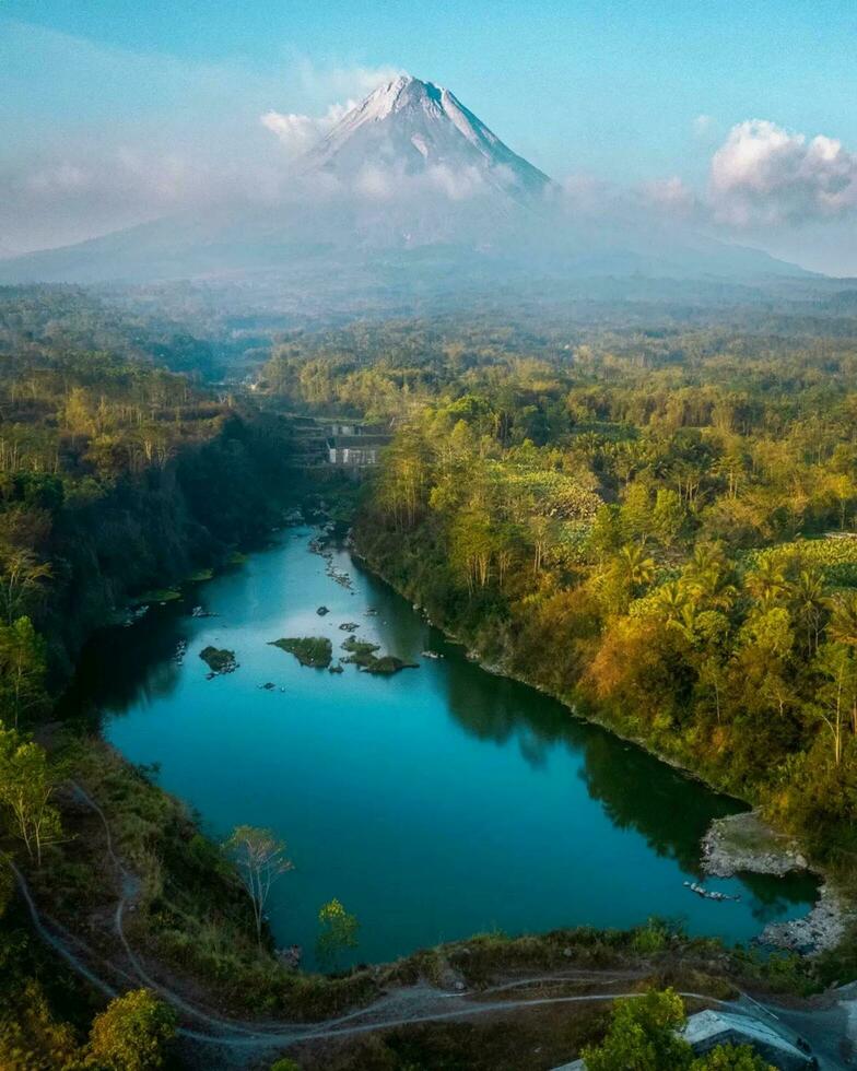 Tranquil Nature's Reflection in Aerial Landscape,Aerial view of serene forest landscape with reflective lake and majestic mountains. photo