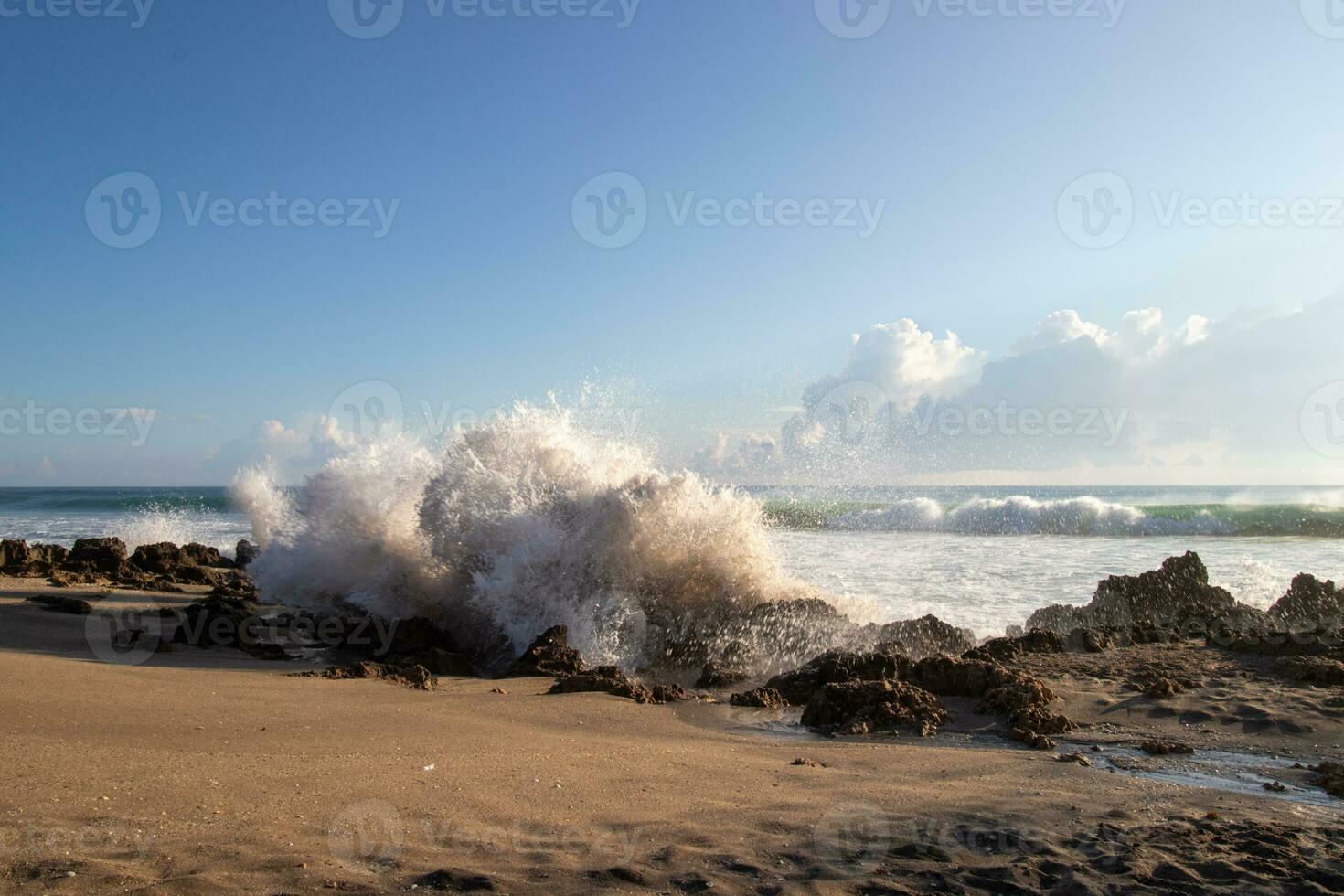 Waves breaking on rocky beach photo