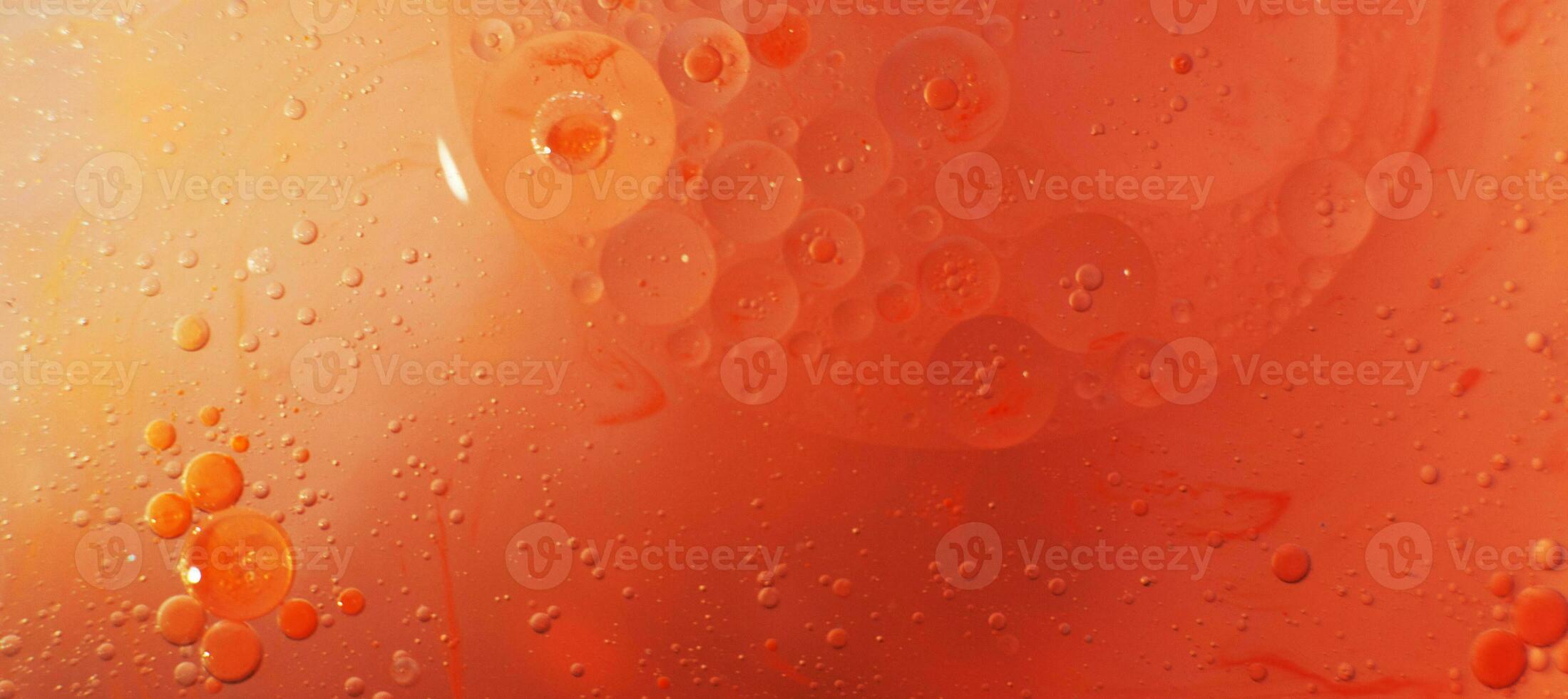 Gold and red Oil bubbles close up. circles of orange and pink water macro. abstract shiny background photo