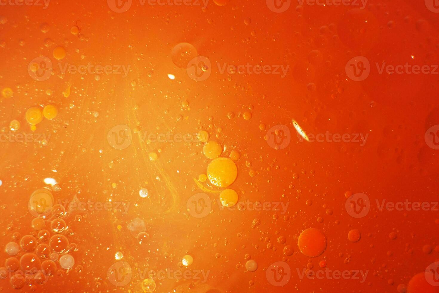 Gold Oil bubbles close up. circles of orange water macro. abstract shiny yellow background photo