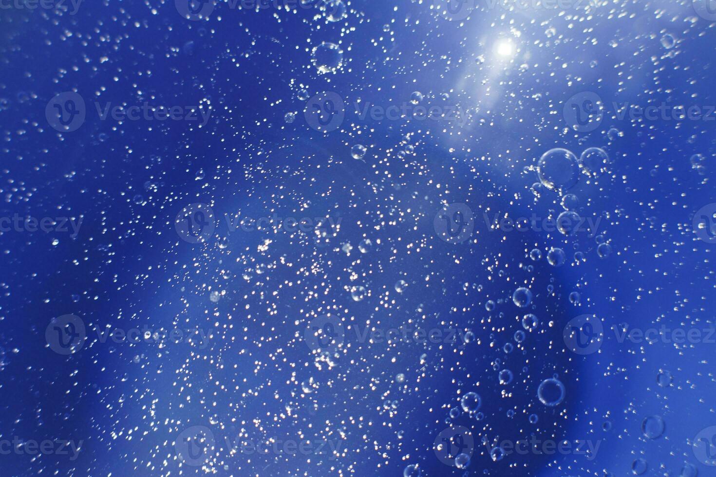 Oil bubbles close up. circles of water macro. abstract light blue background photo