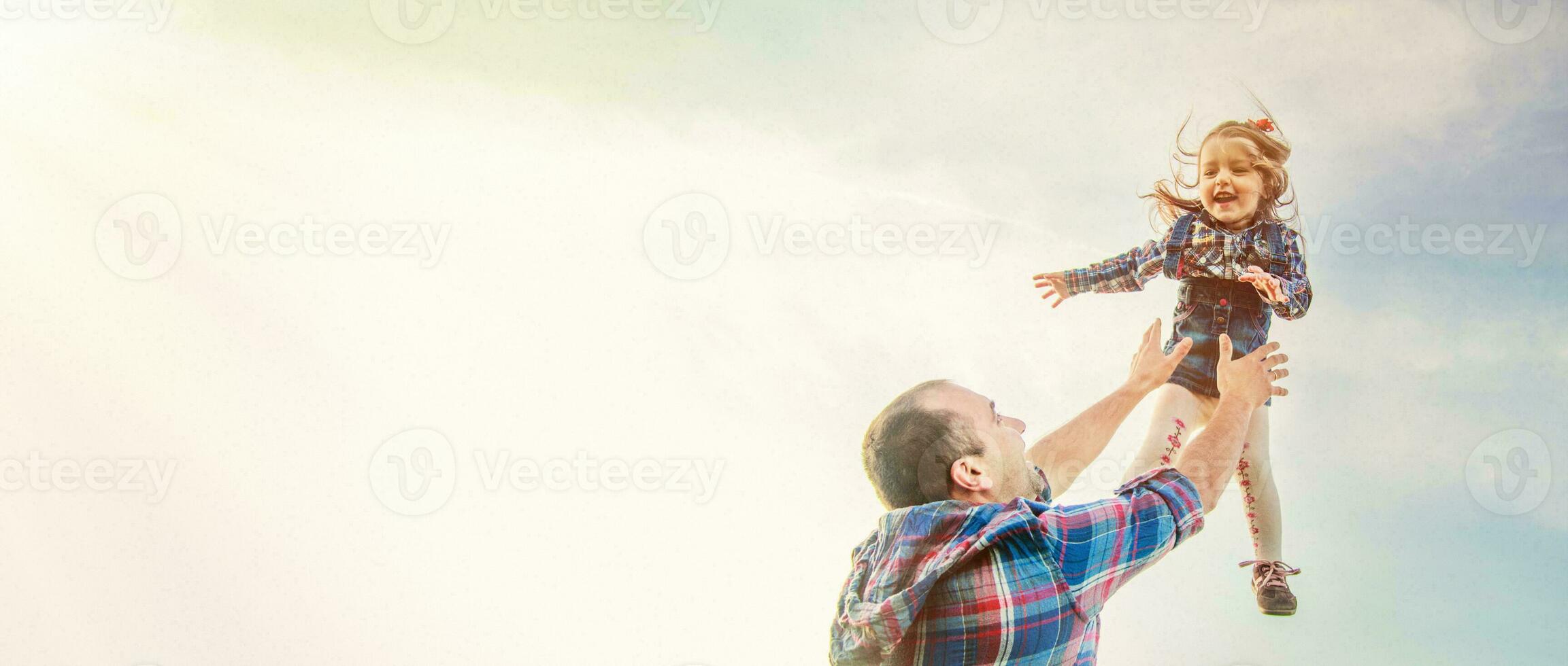 dad throws up the girl in the sky. photo