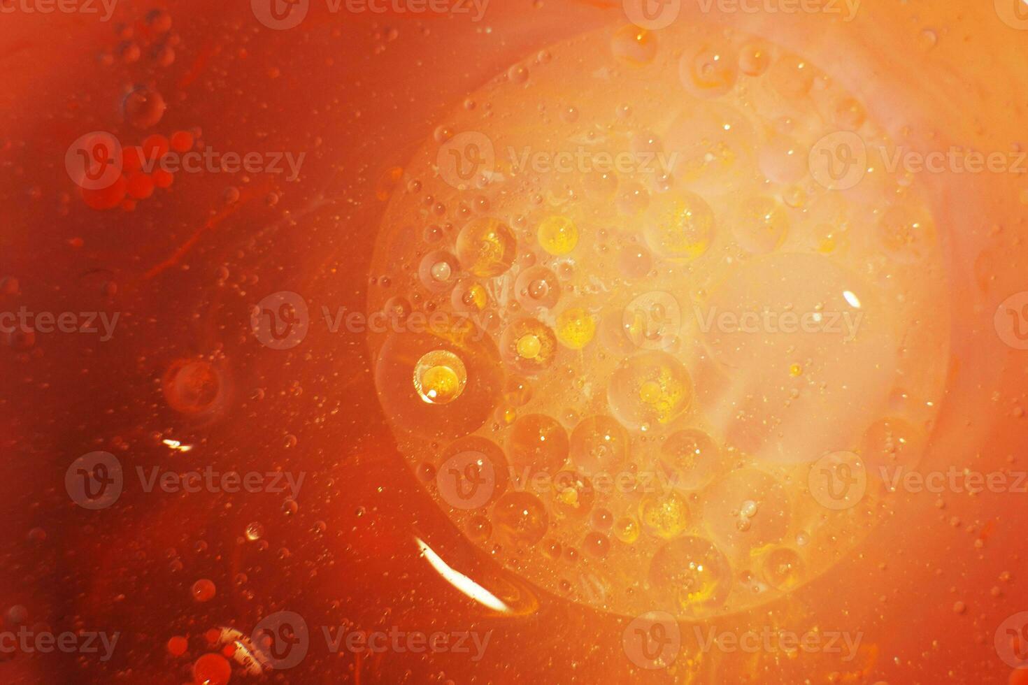 Gold Oil bubbles close up. circles of orange and pink water macro. abstract shiny yellow background photo