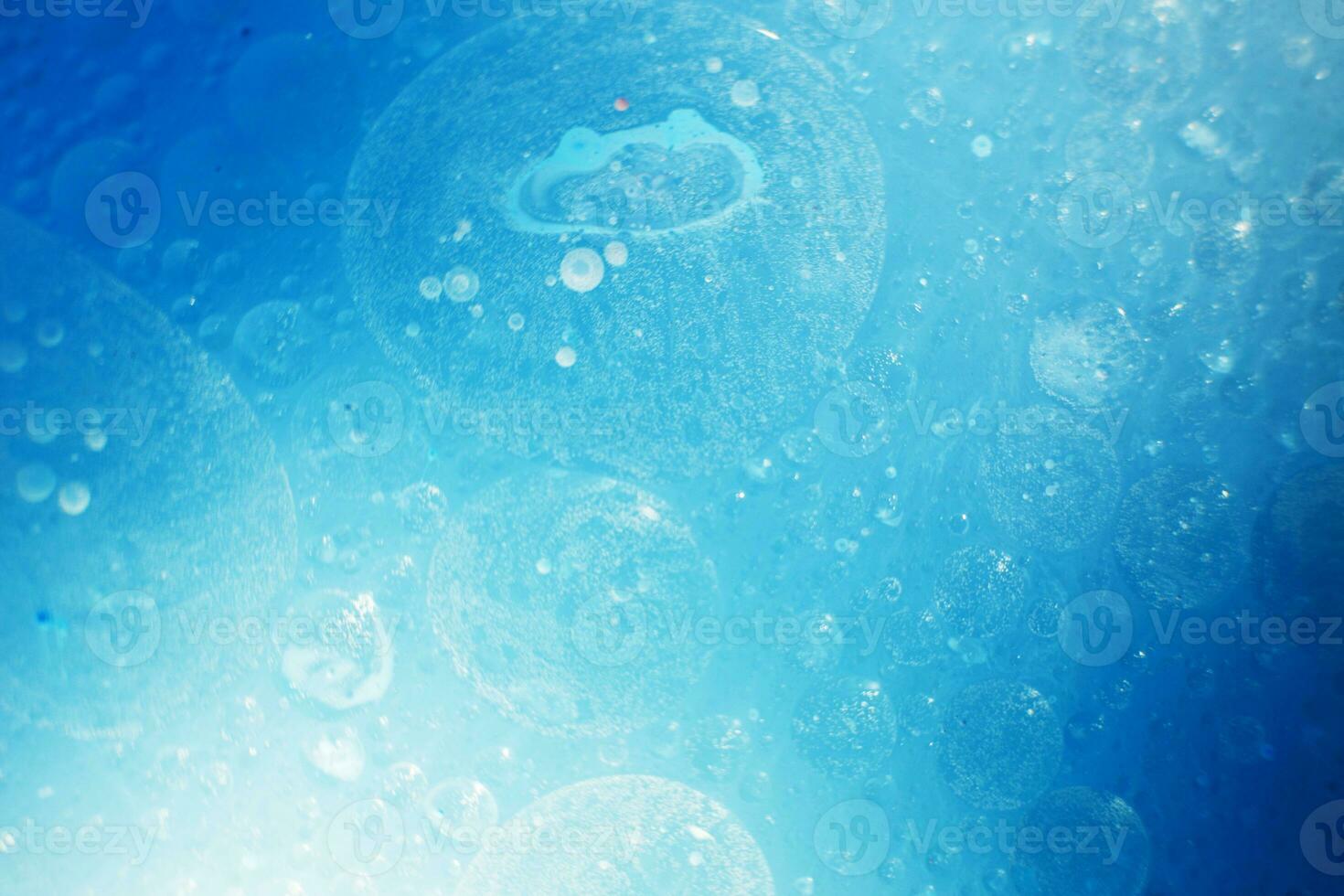 Oil bubbles close up. circles of water macro. abstract light blue background photo