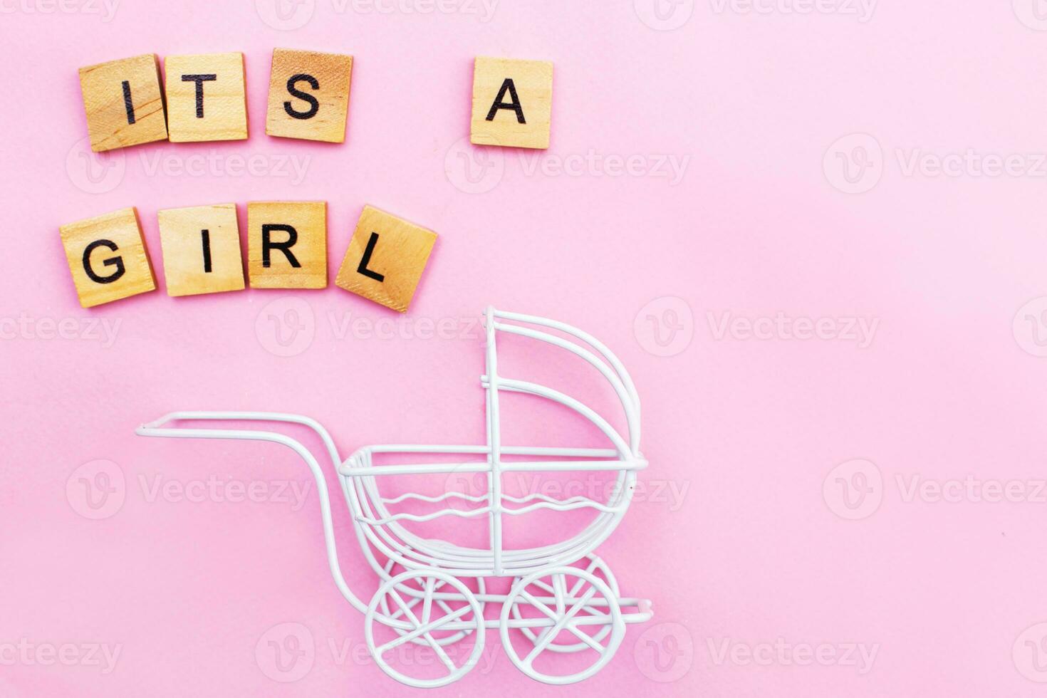 Its a girl. Little vintage white baby carriage stroller or pram on a pink background. photo