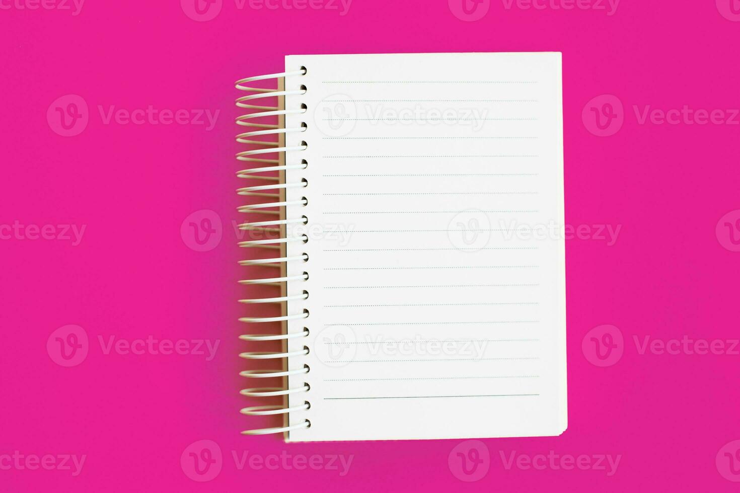 Top view of blank note paper on pink background photo