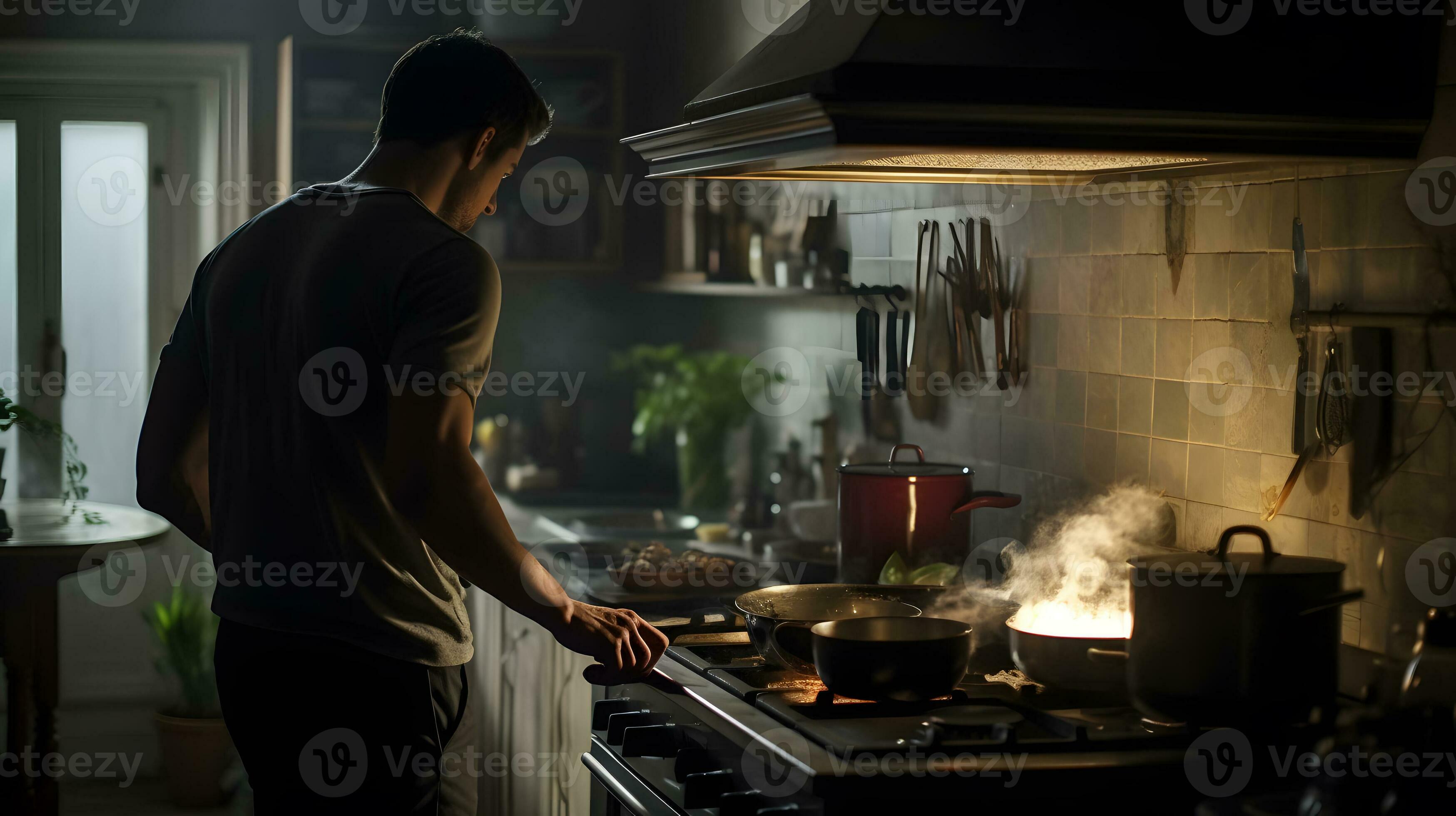 Young man cooking in the kitchen at night, he is preparing food