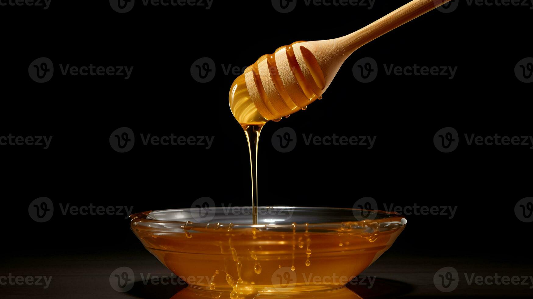 Honey dripping from a wooden honey dipper into a bowl on black background photo