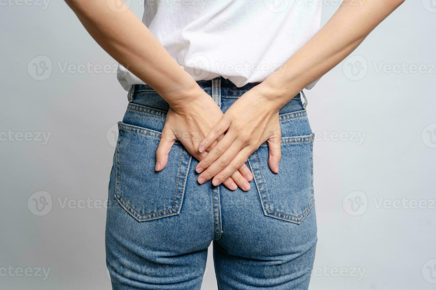 Asian woman uses hands to touch her butt with hemorrhoids health care concept photo