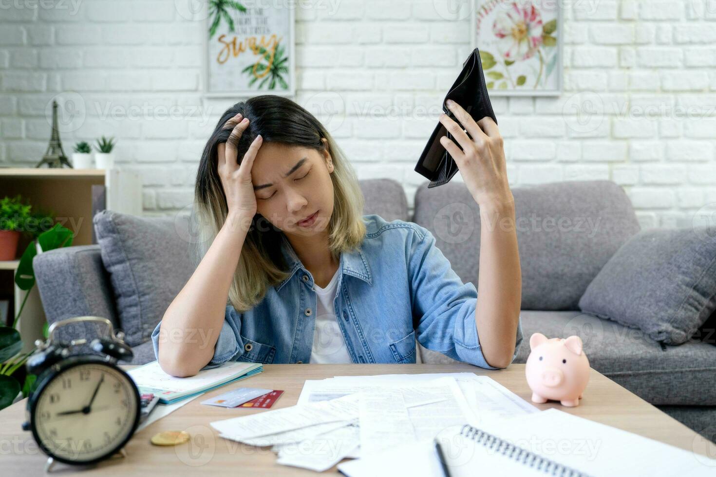 Unemployed Asian woman opening an empty wallet. She was stressed because she didn't have money to pay her debts at home. photo