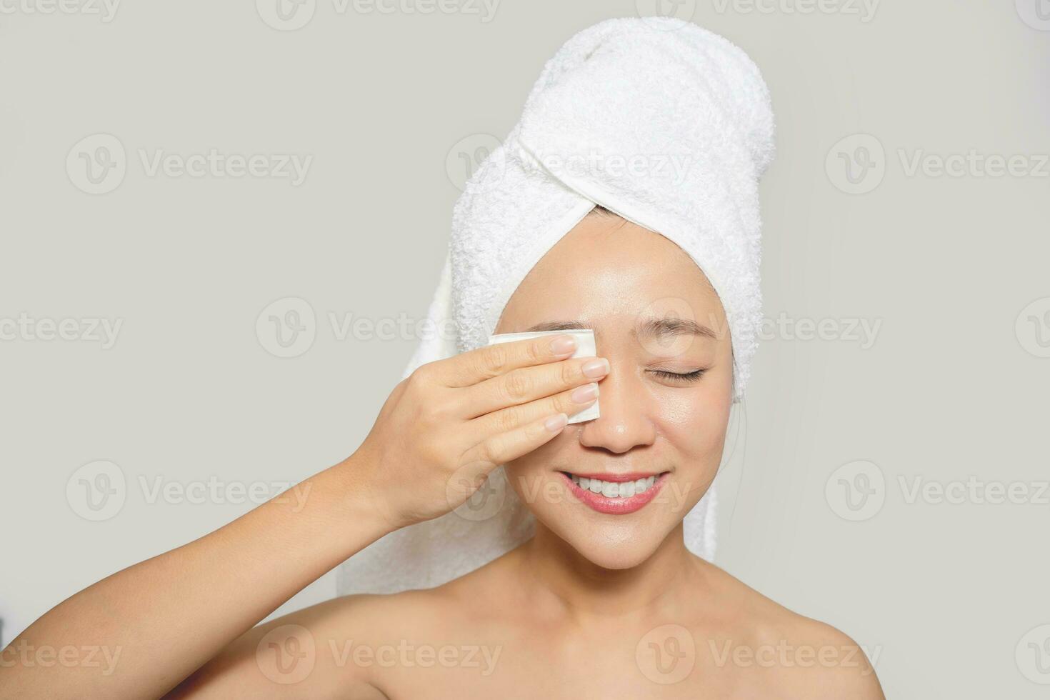 contento asiático mujer utilizando algodón almohadilla limpiar hacer arriba en su cara foto
