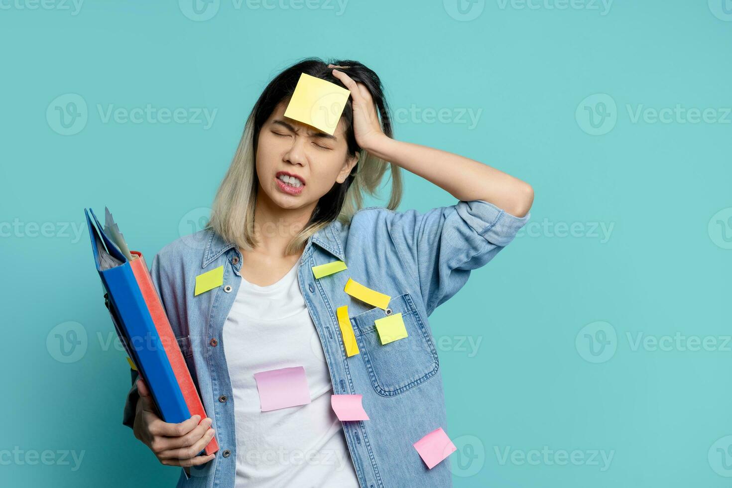 Puzzled office worker overloaded with paper work  isolated on light blue background. photo