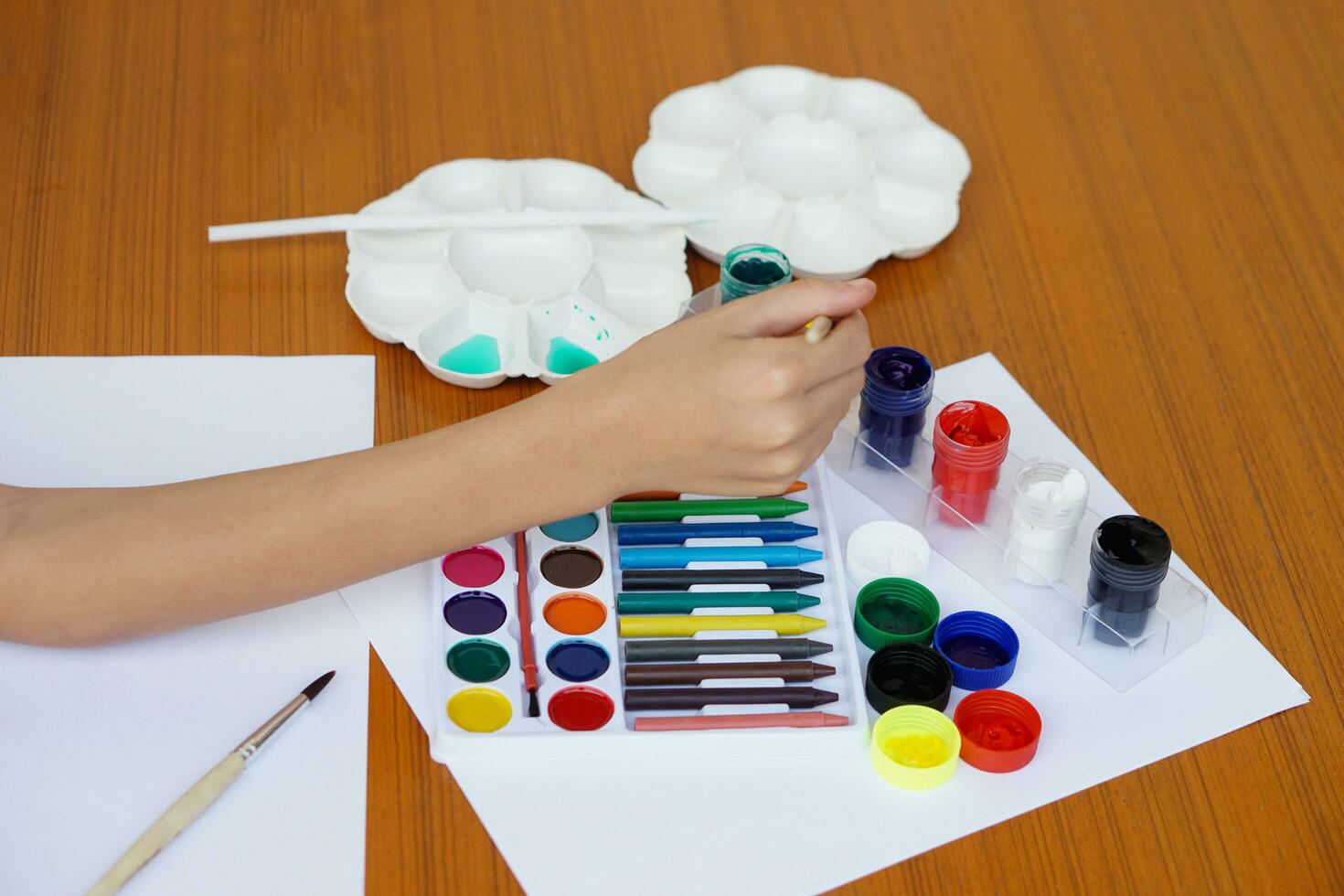 Closeup student is studying art subject, painting, art activity, enjoy and concentrate on favorite activity with many colors. Concept, Education. Learning by doing, enhance kid's imagination. photo
