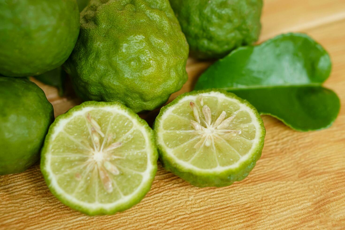 Bergamot fruits and leaves on  wooden background. Concept, herbal fruits with sour taste, can be cooked as food seasoning and use for spa , aroma. Medicinal herb. photo