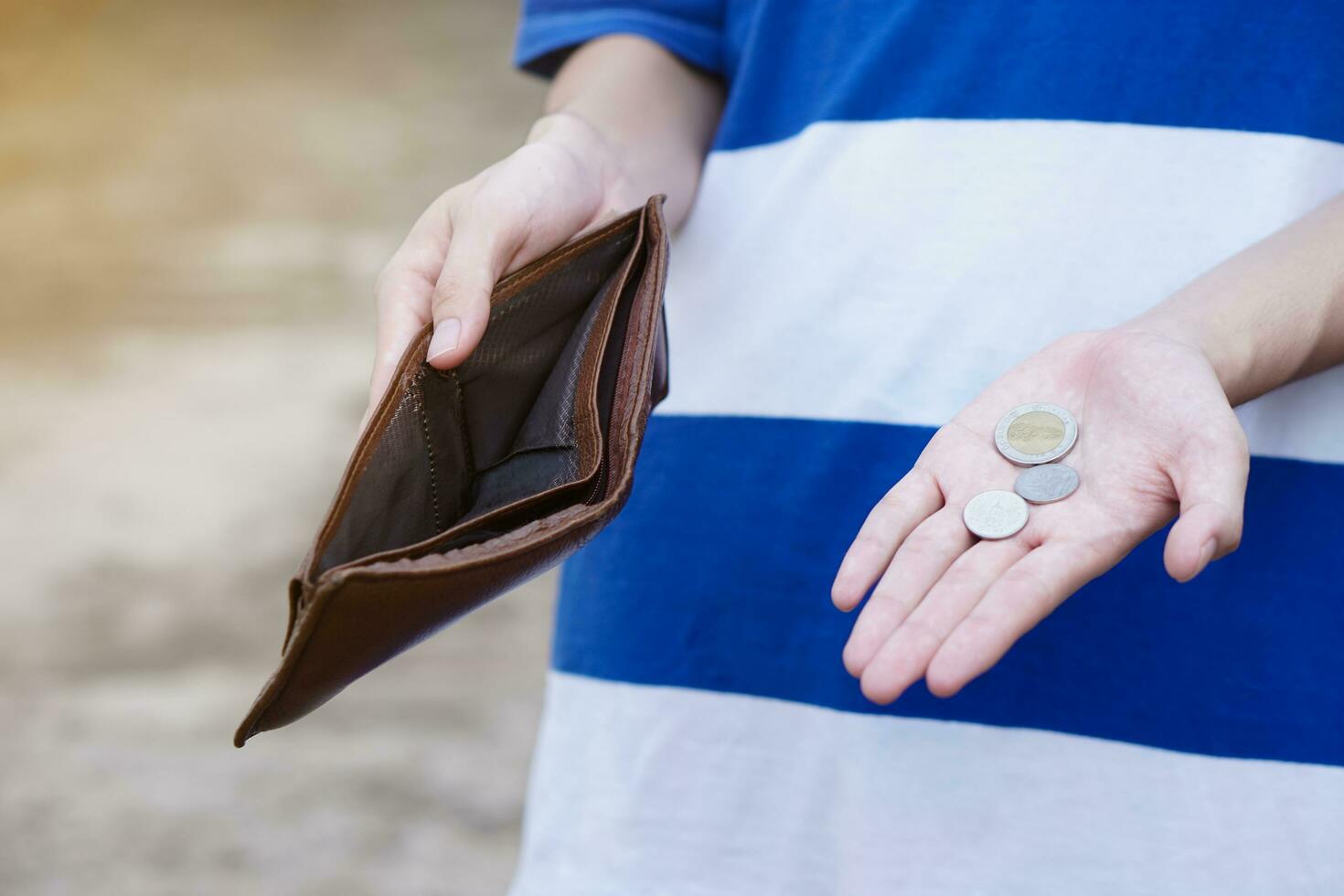 Close up hands holding empty wallet and shows Thai coins money. Concept, poor, bad economic crisis. Financial problems. Broke or less money at the end of month. photo