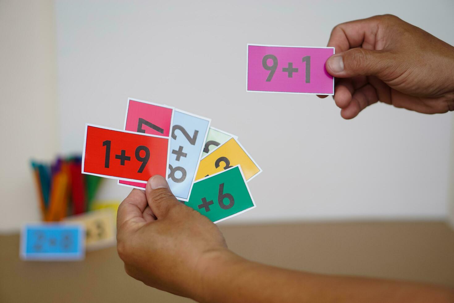 Closeup teacher hand hold paper cards with numbers addition, plus for teaching Math subject. Concept, Education, Teaching aid, materials for kids. Education, Practice calculate photo