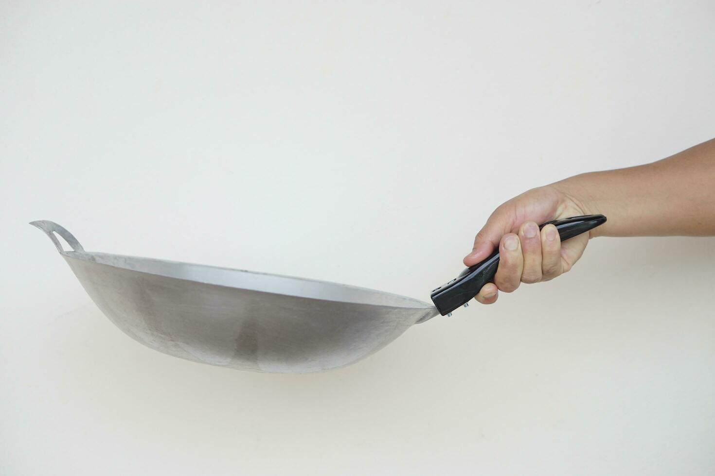 Close up hand hold frying pan for cooking. Concept, cooking equipment in kitchen. Kitchenware. photo
