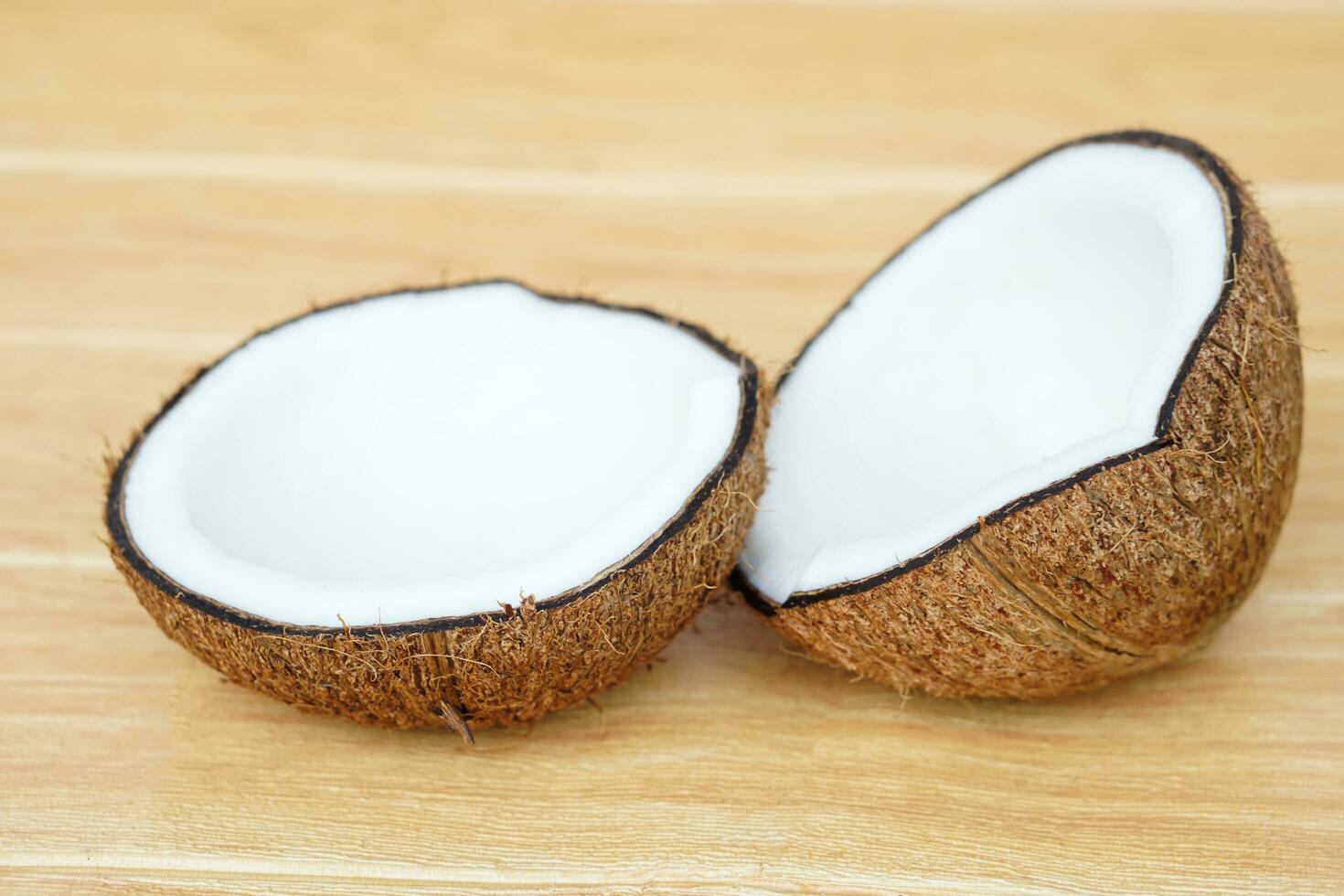 Half cut coconut fruits to show white meat inside on brown background. Concept , Food ingredient for making coconut milk  and cooking Thai dessert from nature. photo