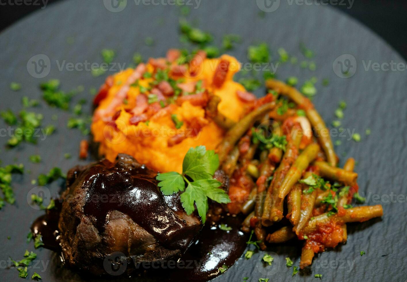 Veal cheeks with sweet potato puree and bacon with beans in tomato sauce and garlic photo