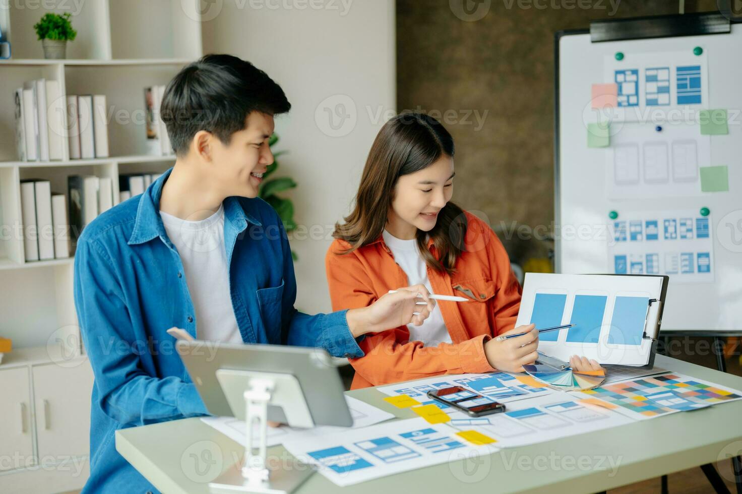 UX developer and ui designer brainstorming about mobile app interface wireframe design with customer breif and color code at office. photo