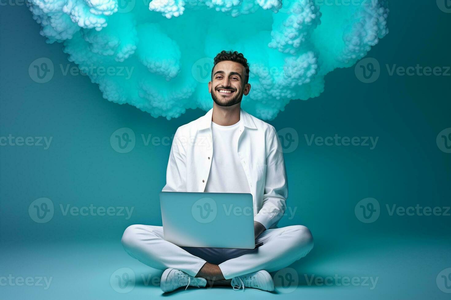 a man is sitting with a laptop in front of clouds photo