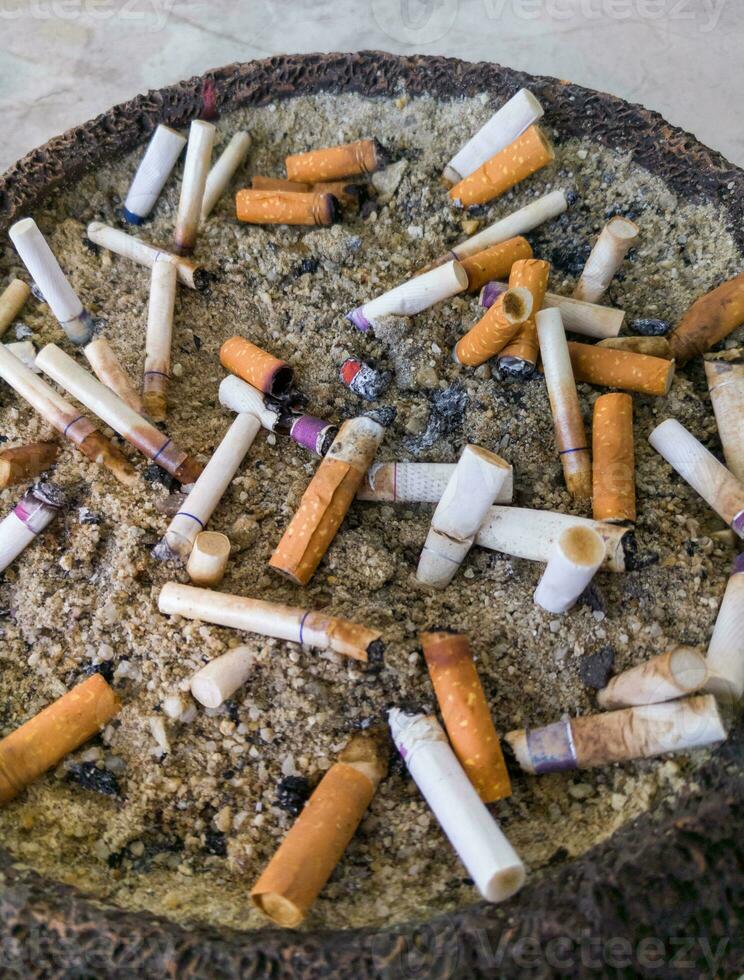 Closeup of the many cigarette butts in the ashtray. photo