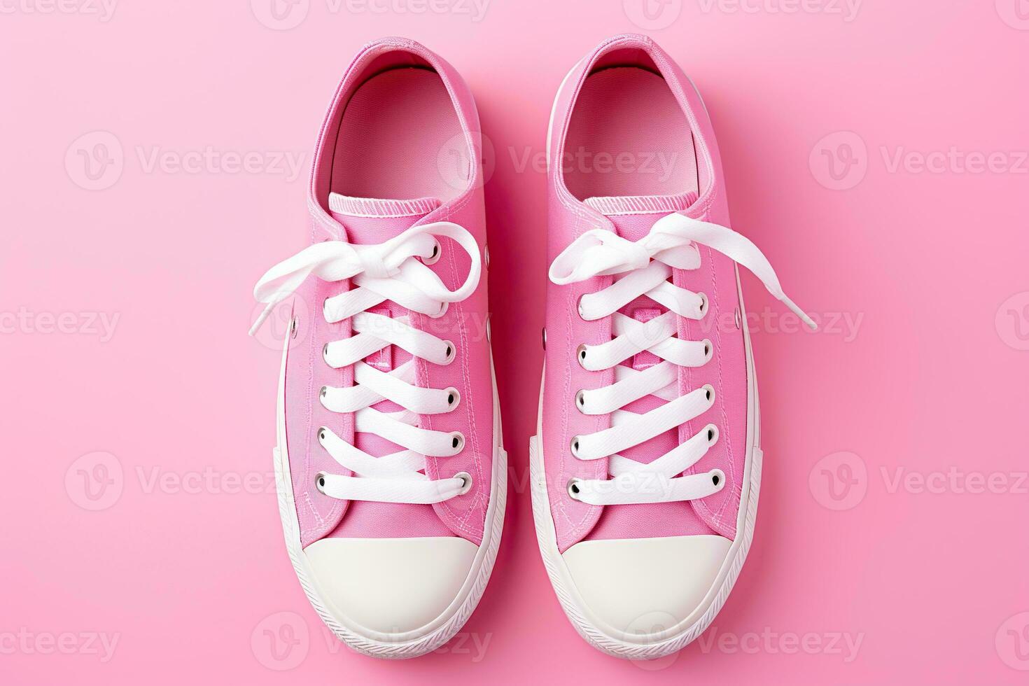 New pair of pink woman sneakers on pink background. Lifestyle, sneaker sport shoe. Top view photo
