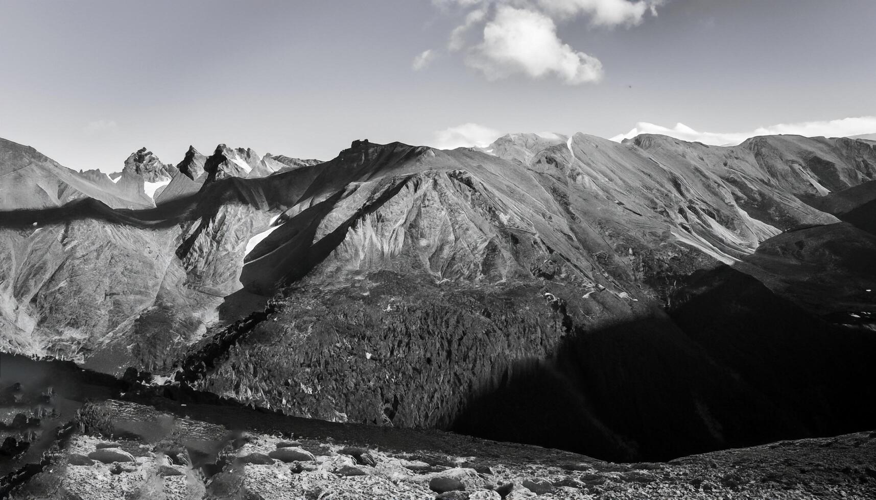 A mountain view with a person standing on top of a slope photo